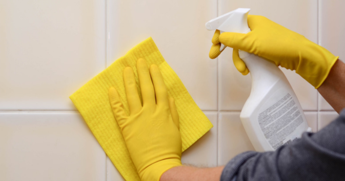 Person with gloves cleaning tile